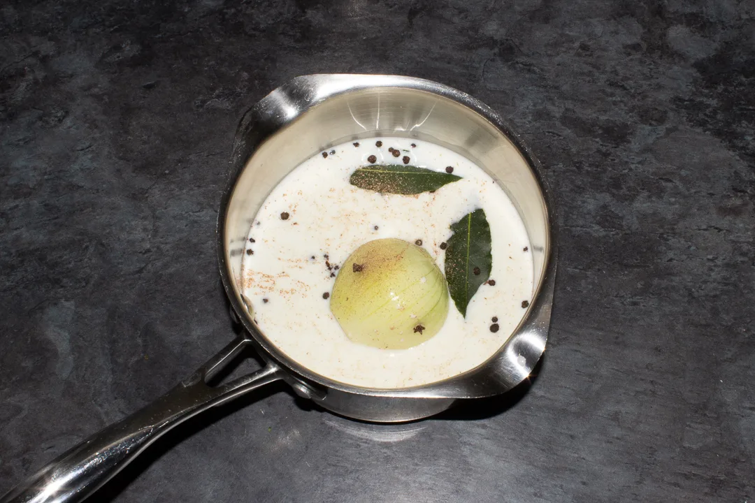 Milk, onion and spices in a saucepan.
