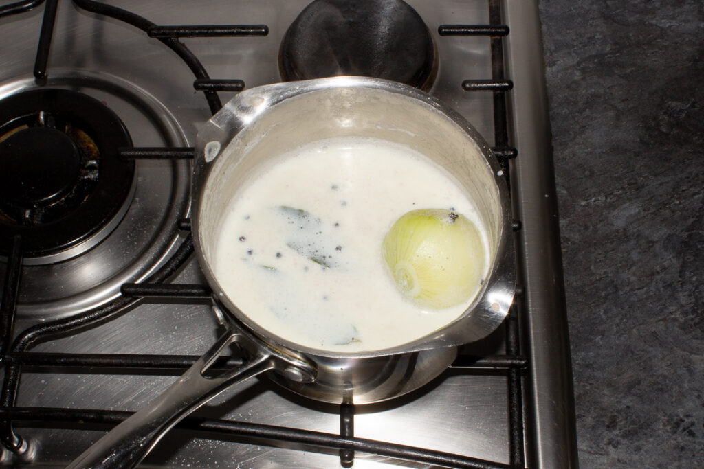 Boiled milk, onion and spices in a saucepan on the stove top.