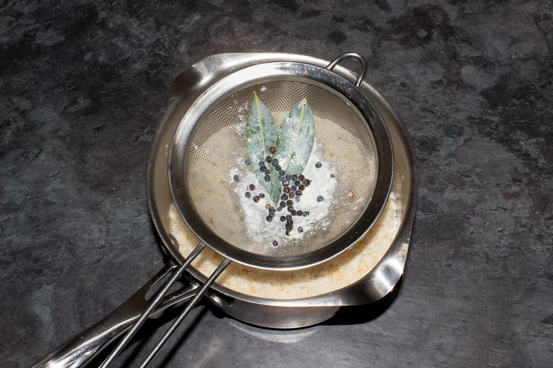 A sieve over a saucepan that's had the infused milk poured through it.