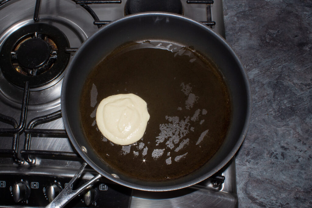 Drop scone batter in a frying pan on the stove.