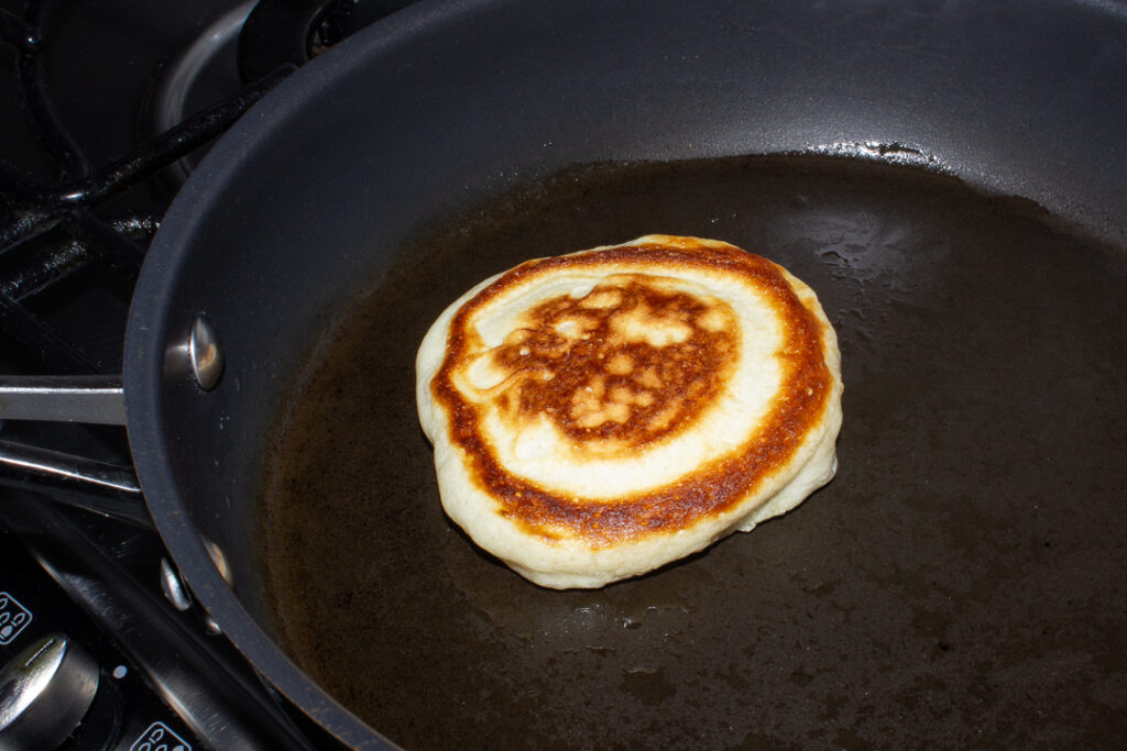 Cooked drop scone in a frying pan.