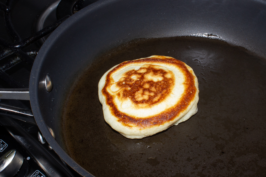 Cooked drop scone in a frying pan.