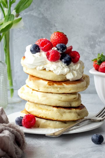 Stacked drop scones topped with cream and berries.