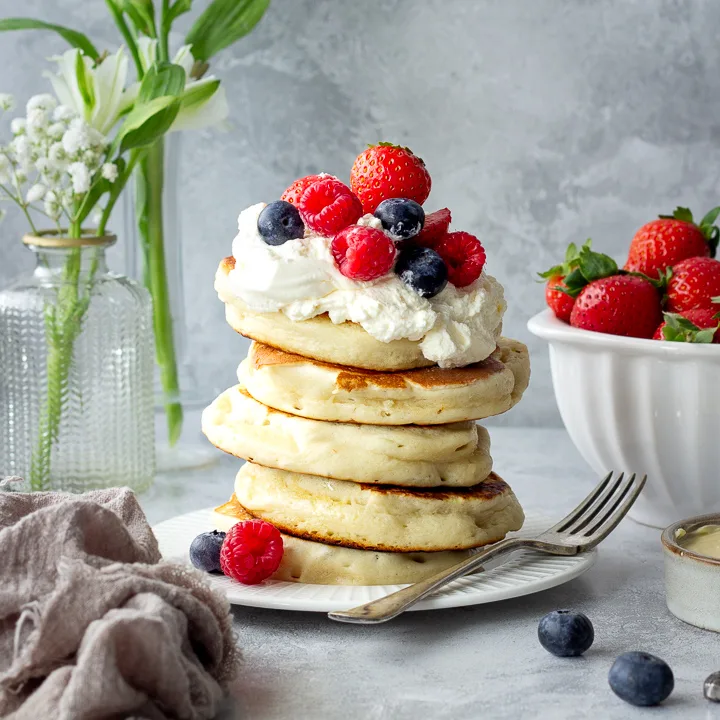 Stacked drop scones topped with cream and berries.