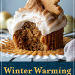 A bitten into gingerbread cupcake on a wrapper, topped with a gingerbread biscuit snowflake. A text overlay says "Winter warming gingerbread cupcakes".