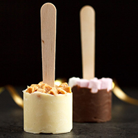 White and milk hot chocolate sticks on a worktop.