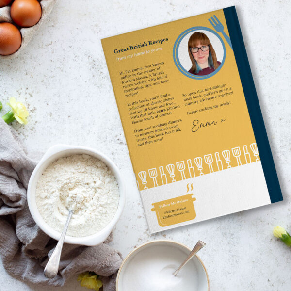 The back cover of 'Great British Recipes, from my home to yours' book on a worktop surrounded by ingredients.