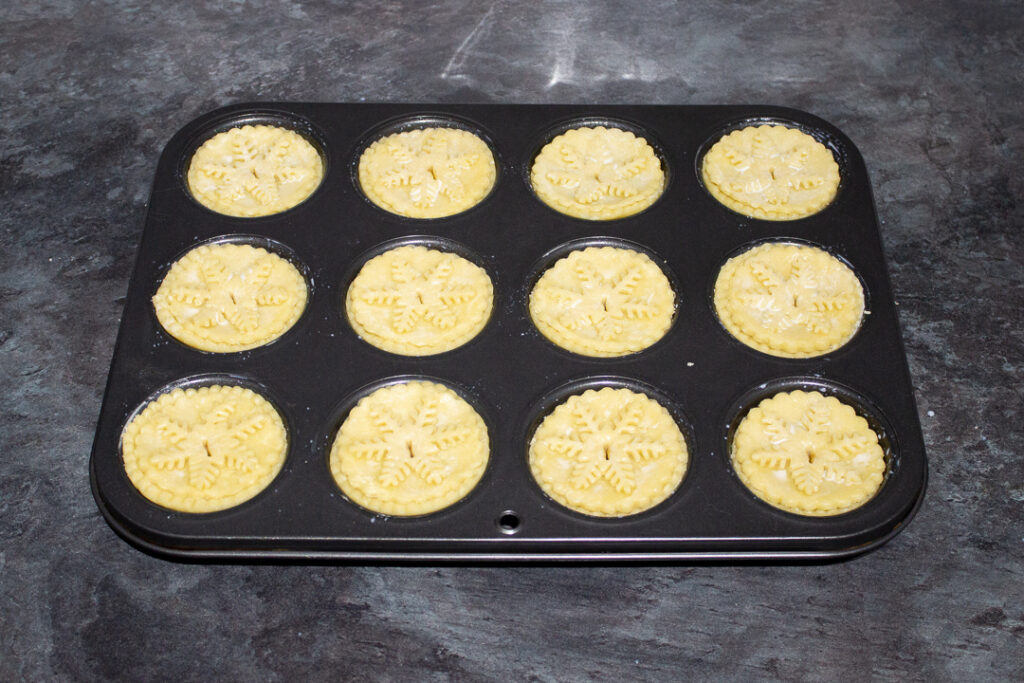 Mince pies in a pie tin ready for the oven.