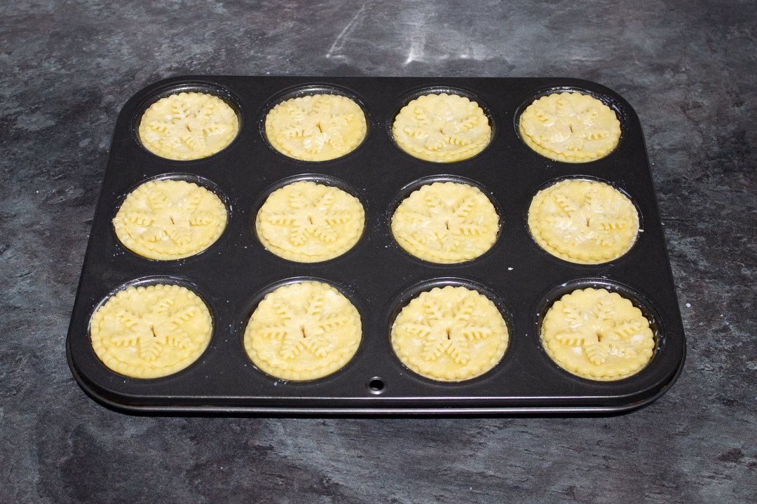 Mince pies in a pie tin ready for the oven.