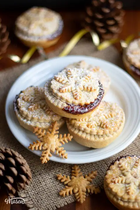 Shortcrust pastry mince pies on a plate with gold curling ribbon around it.