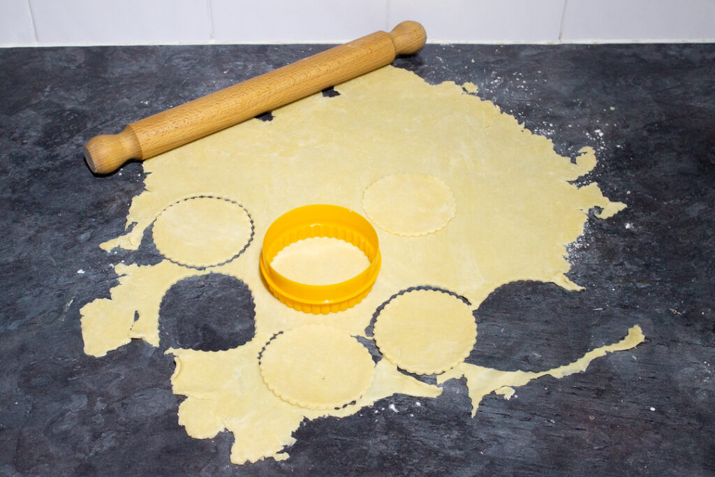 Shortcrust pastry being rolled and cut out.