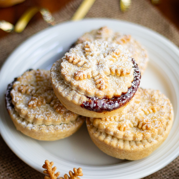 Shortcrust pastry mince pies on a white plate.