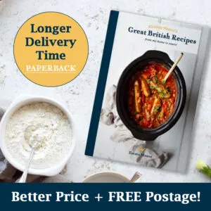 The 'Great British Recipes, from my home to yours' paperback book on a worktop surrounded by ingredients.