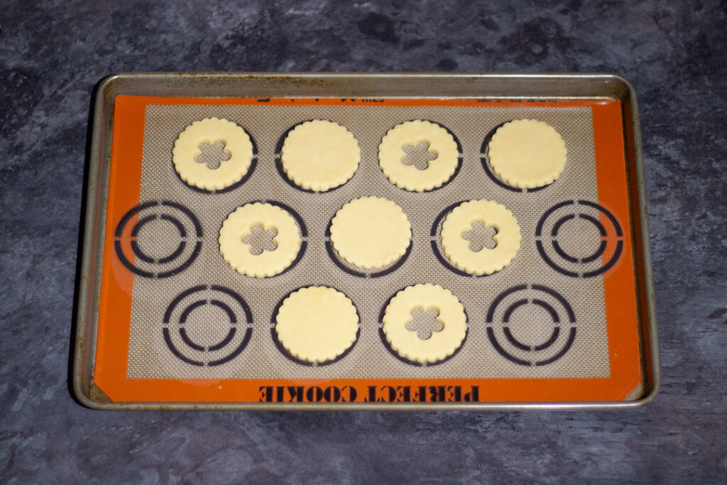 Unbaked biscuits on a lined baking tray.