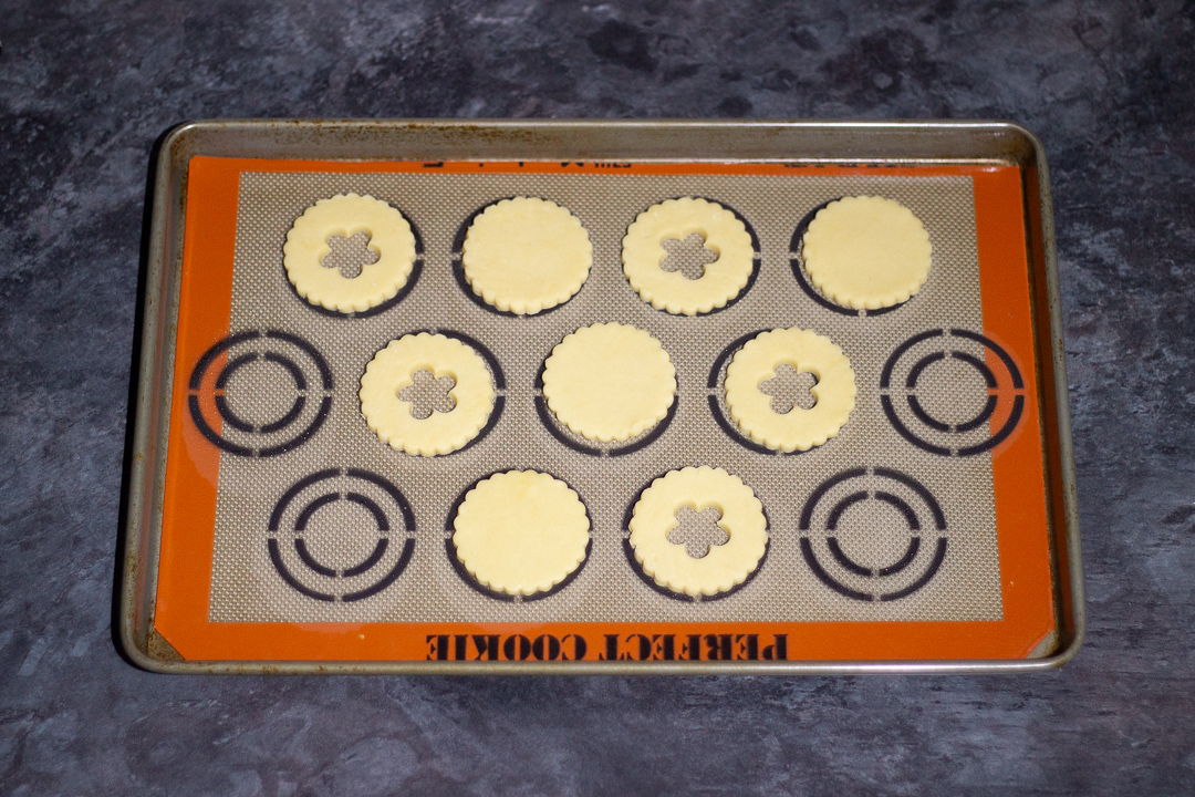 Unbaked biscuits on a lined baking tray.