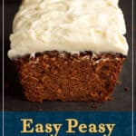 A partially sliced spiced carrot cake loaf on a work surface with a light brown linen napkin behind it.