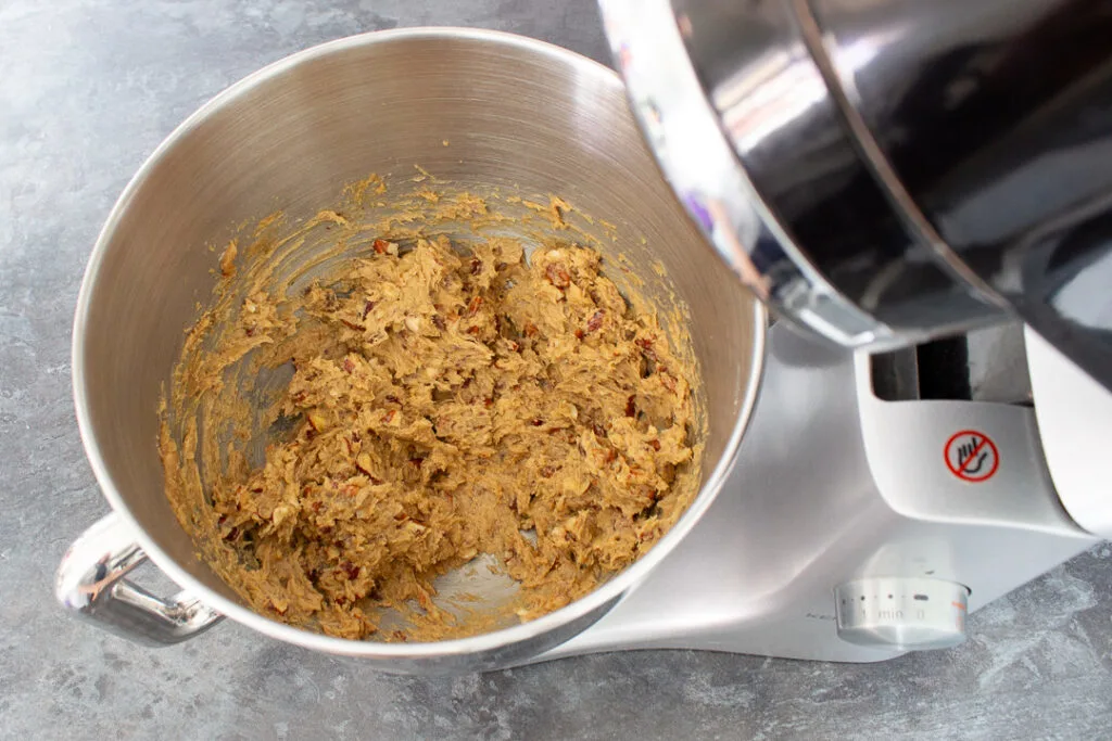 Creamed butter, salt, sugar, mixed nuts, egg and golden syrup in the bowl of an electric stand mixer.