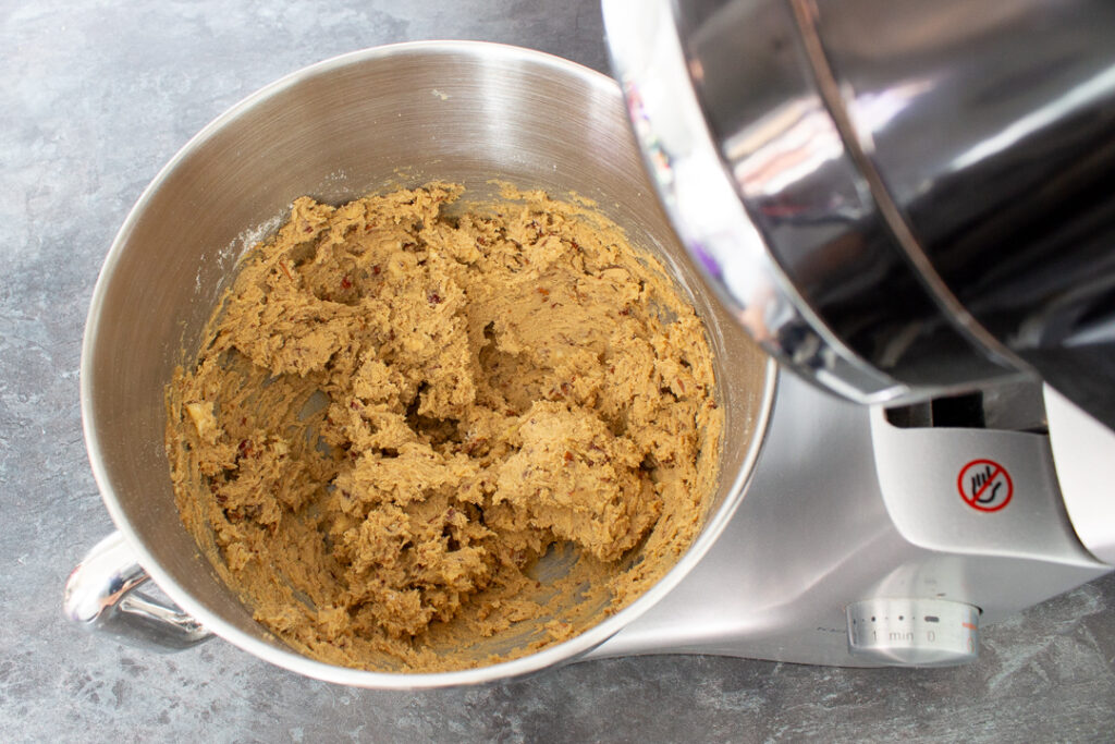 Nut biscuit dough in the bowl of an electric stand mixer.