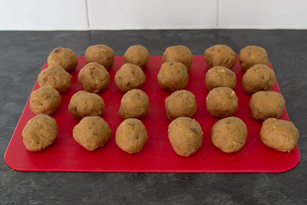 Nut biscuit dough balls on a chopping board.