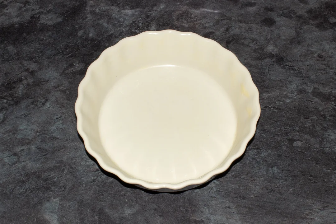A greased baking dish on a kitchen worktop.