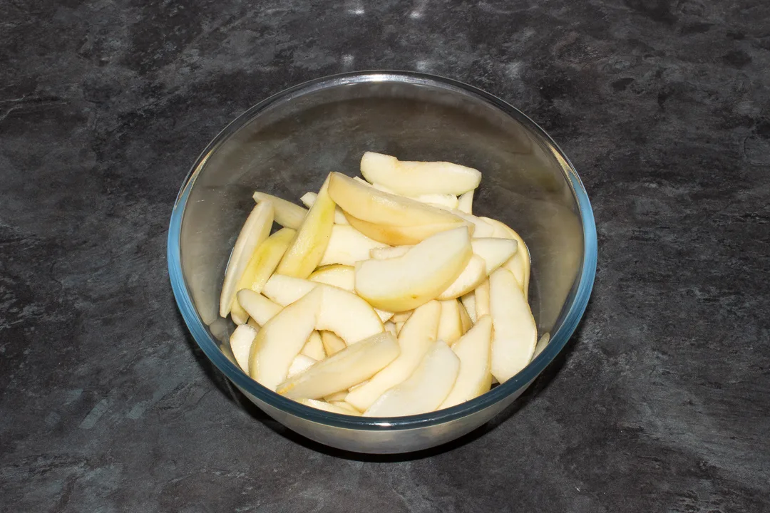 A mixing bowl filled with sliced pears.
