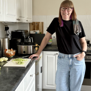 Emma Mason cooking in the kitchen, with a tea towel over her shoulder.
