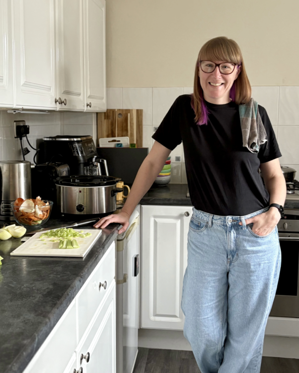 Emma Mason cooking in the kitchen, with a tea towel over her shoulder.