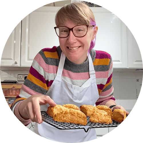 Emma holding a rack of freshly baked cheese scones that were made on a live online cook-along.