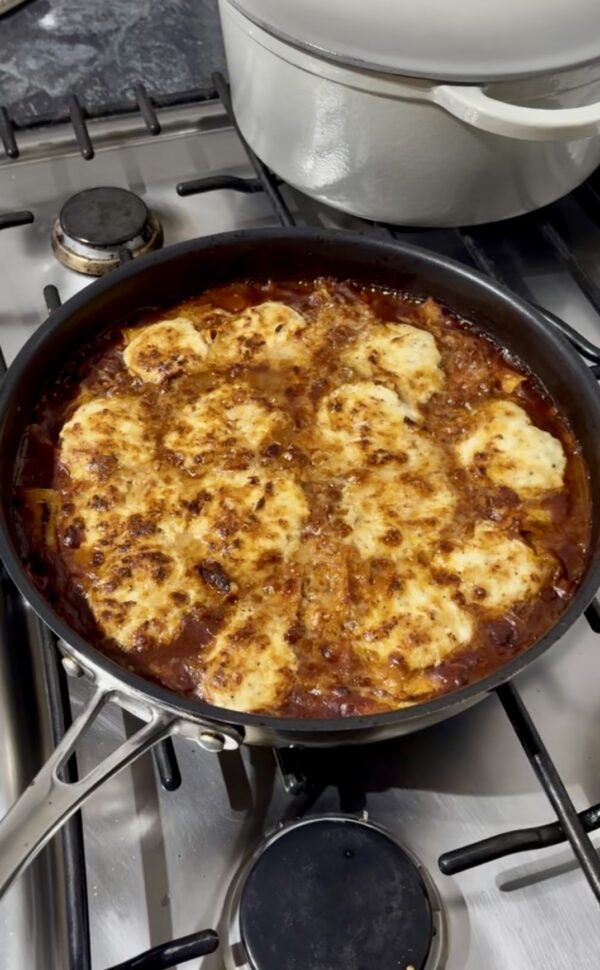 A large frying pan filled with a freshly made stove top lasagne.