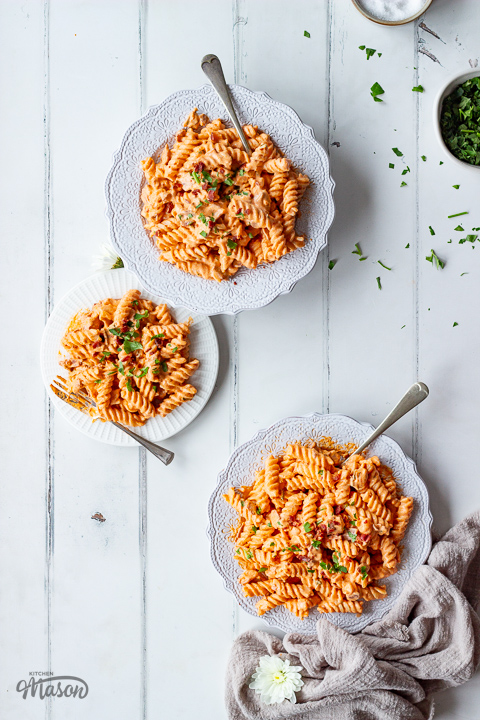 3 plates of creamy bacon pasta with forks on the side.