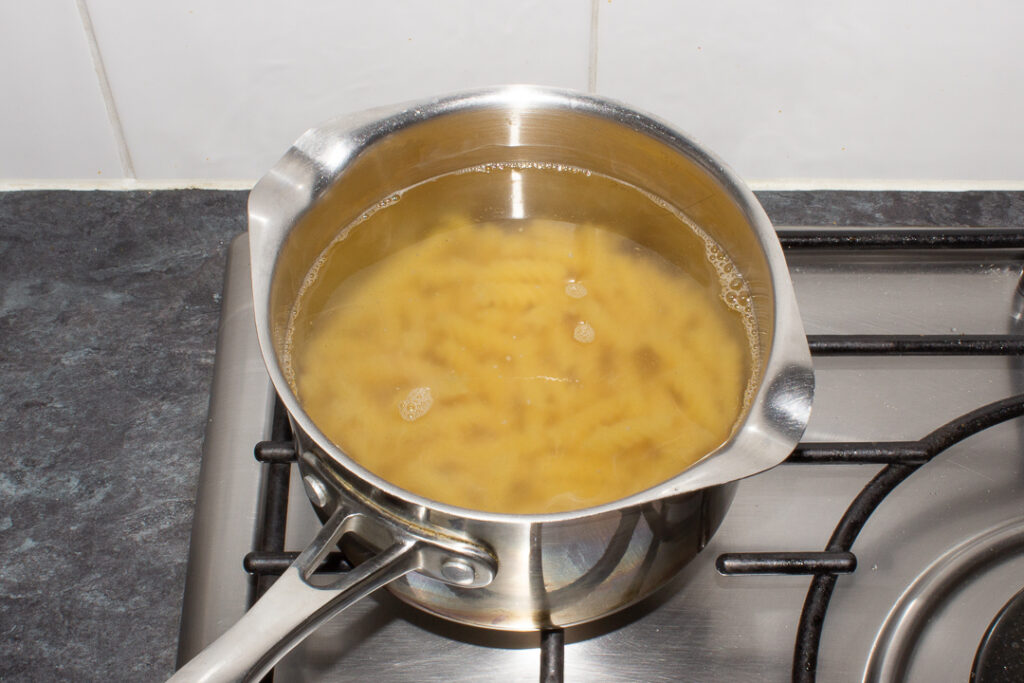 Pasta in hot water in a saucepan.