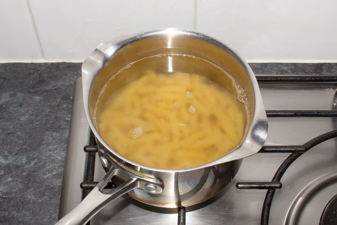 Pasta in hot water in a saucepan.