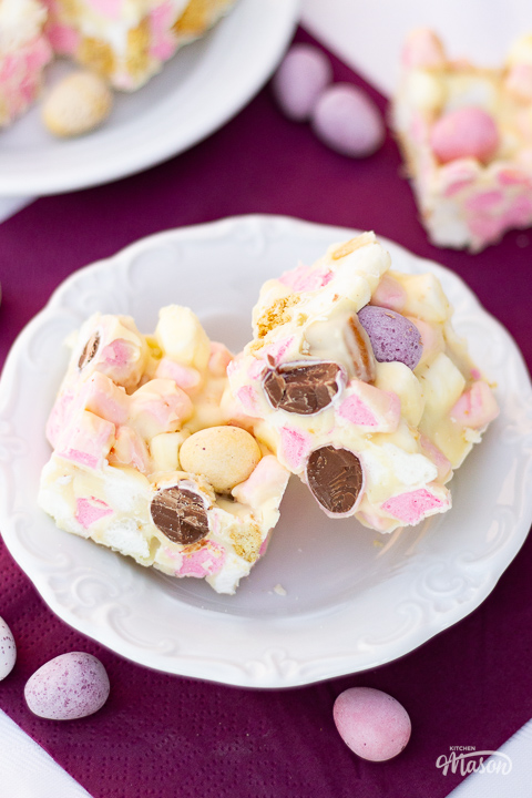 A plate of white chocolate Mini Egg rocky road bars with extra Mini Eggs to the side.