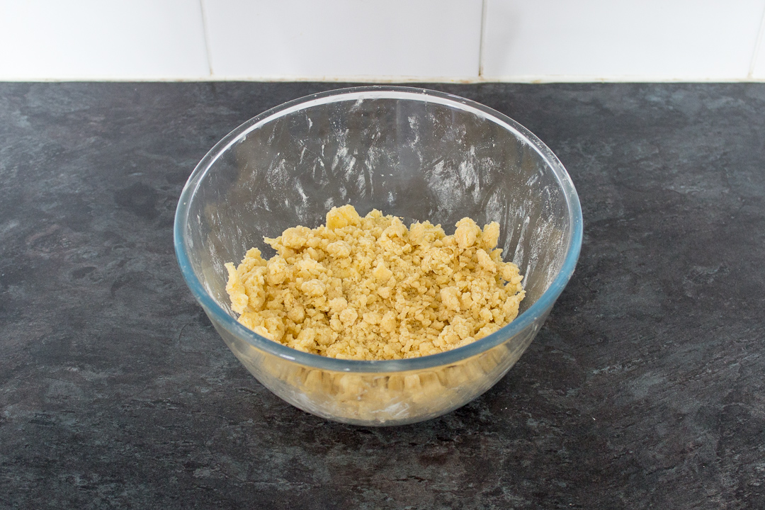 A mixing bowl filled with crumble mixture.