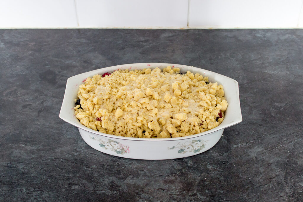 A Summer fruit crumble sprinkled with sugar ready for the oven.