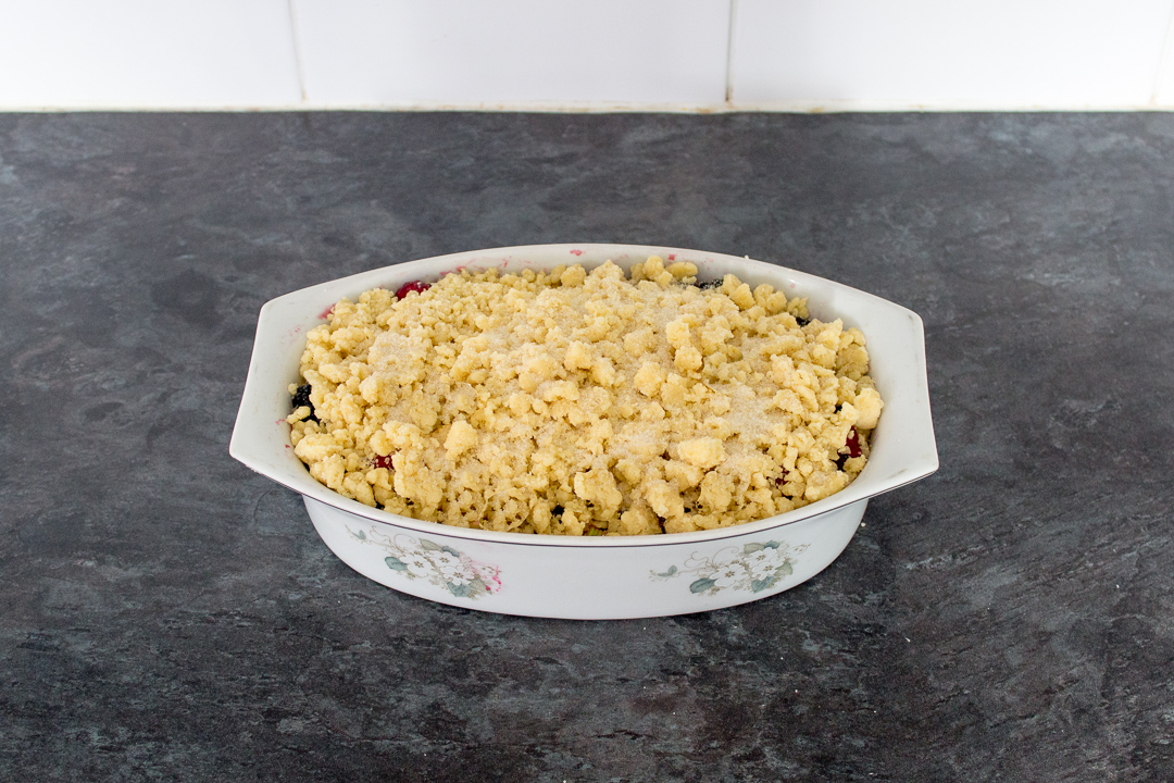 A Summer fruit crumble sprinkled with sugar ready for the oven.