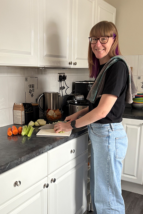Emma chopping vegetables in her kitchen