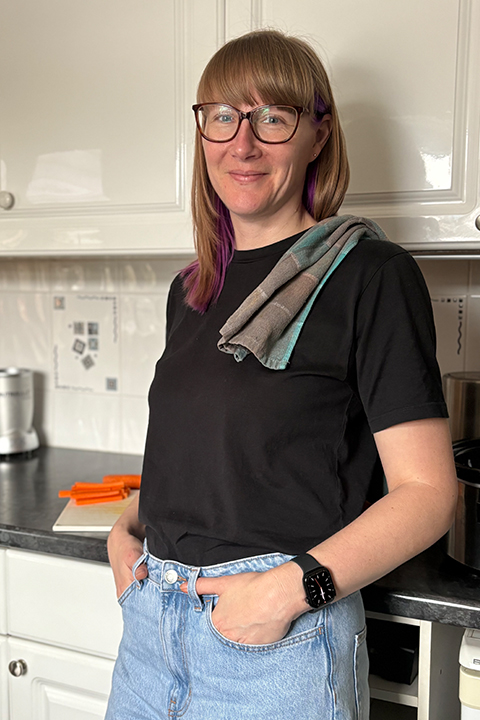 Emma smiling, standing in her kitchen with a tea towel over her shoulder.