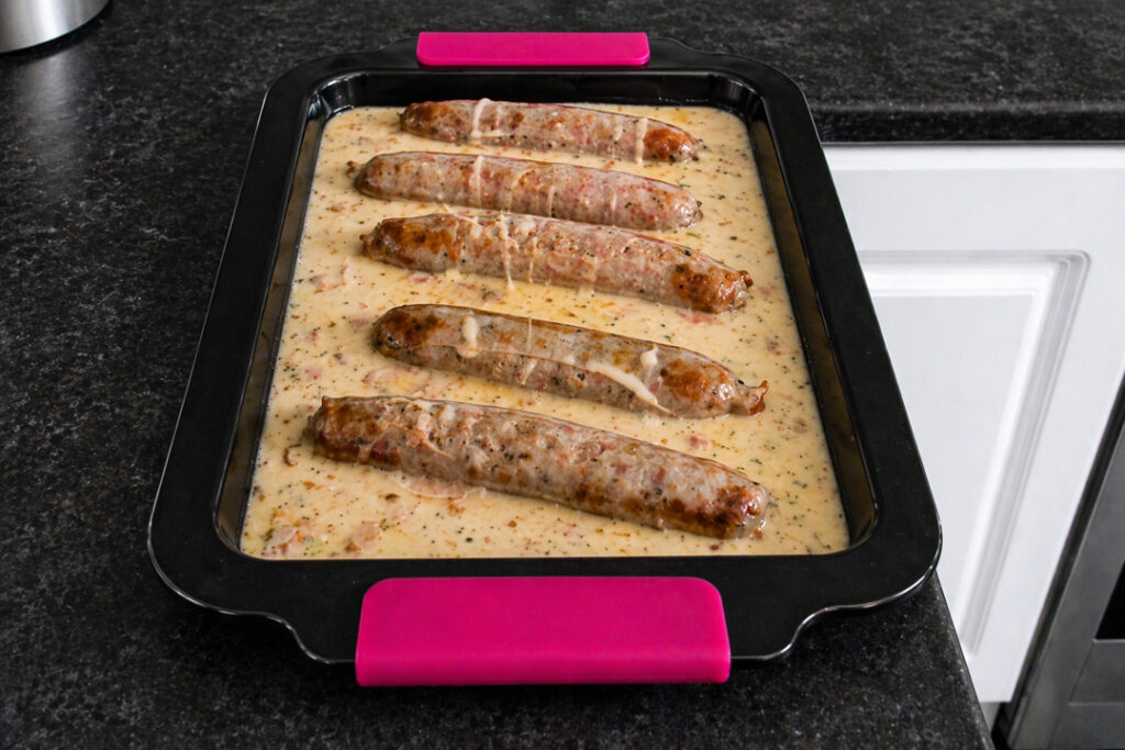 An uncooked toad in the hole in a roasting dish on a kitchen worktop.
