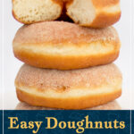 A stack of homemade sugared homemade ring doughnuts, the top one is cut in half to show it's fluffy interior texture. A text overlay says "Easy doughnuts, perfect every time!".