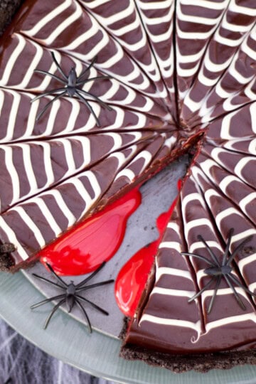 A chocolate tart decorated with a white chocolate spiderweb on top, and filled with caramel blood.