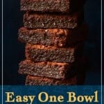 Super fudgey brownies in a stack against a dark blue backdrop. A text overlay says 'Easy one bowl super fudgy brownies'.